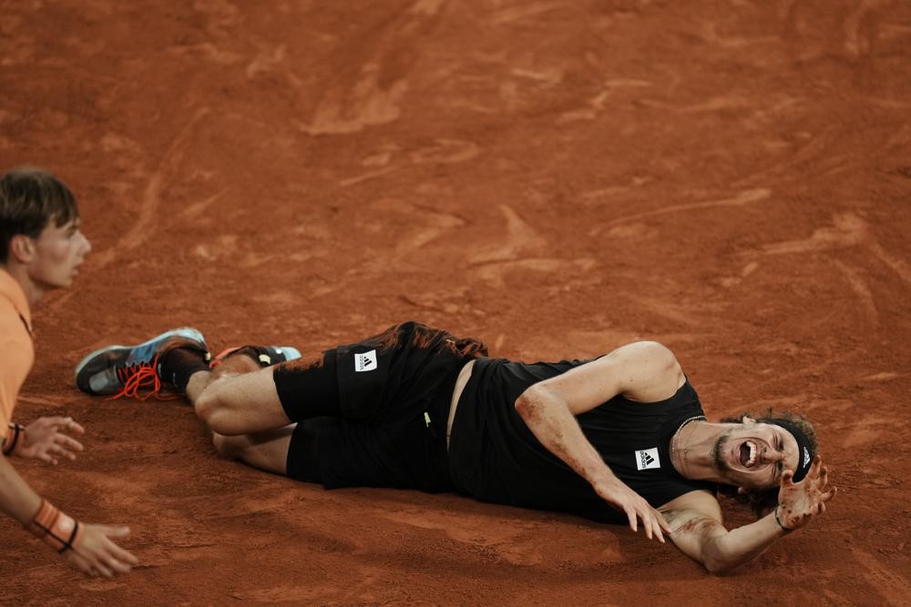 Germany's Alexander Zverev grimaces in pain after twisting his ankle during the semifinal match against Spain's Rafael Nadal at the French Open tennis tournament in Roland Garros stadium in Paris, France, Friday, June 3, 2022. (AP Photo/Thibault Camus)